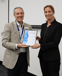 Dr France Milat receiving her award from Monash Health CEO, Mr Andrew Stripp.