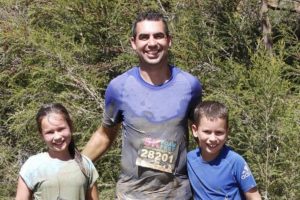 Dr Jason Cain taking part in a muddy 5km run with his children