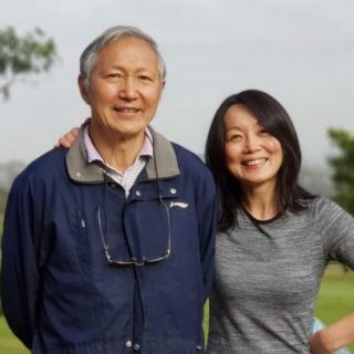 Dr Jun Yang standing with her father in a park