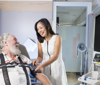 Dr Jun Yang taking a patients blood pressure