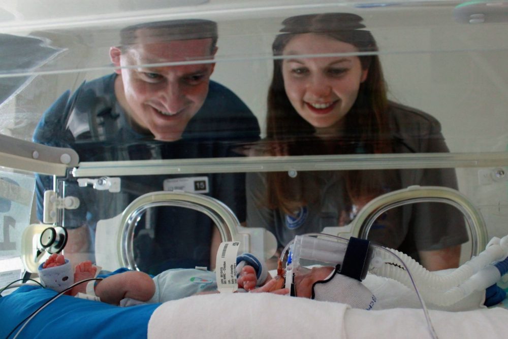 Darren and Dani gaze lovingly into baby Jack's crib