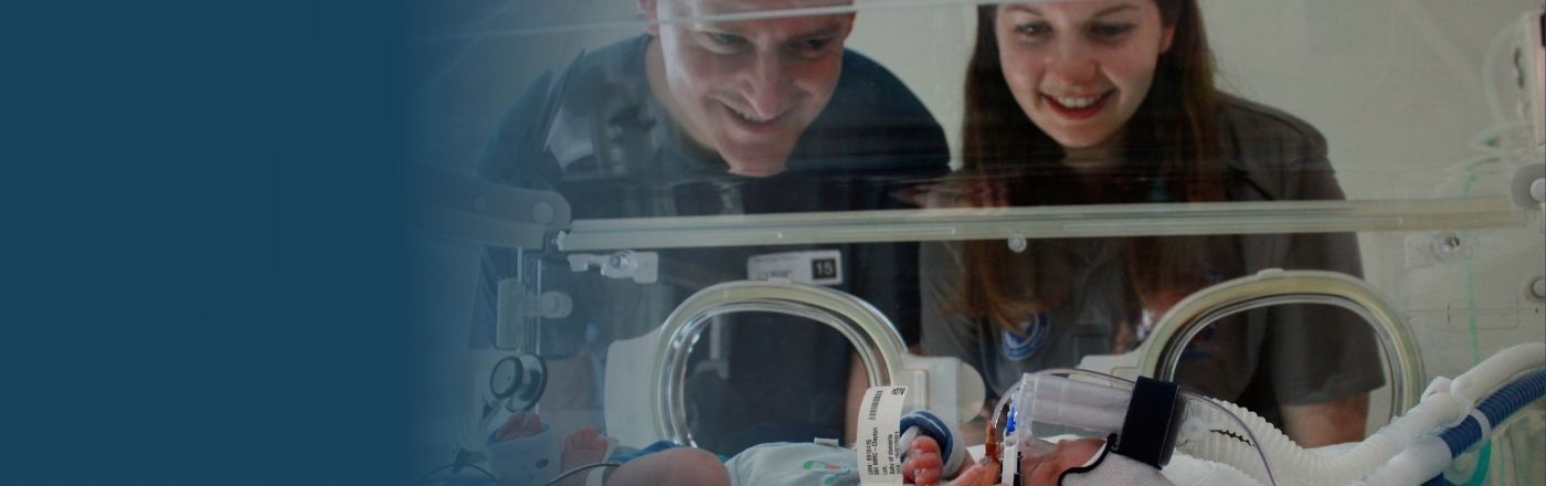 Darren and Dani gaze lovingly into baby Jack's crib