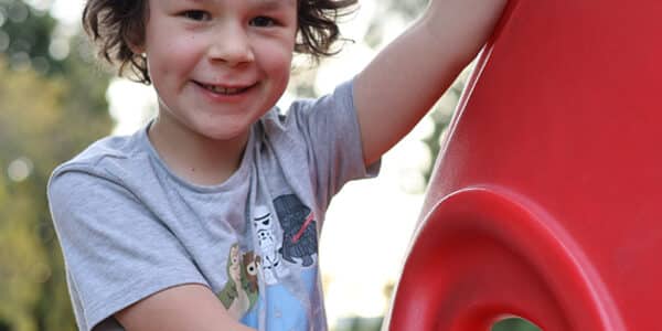 Luca Boggia rare brain tumor survivor playing in a park and laughing