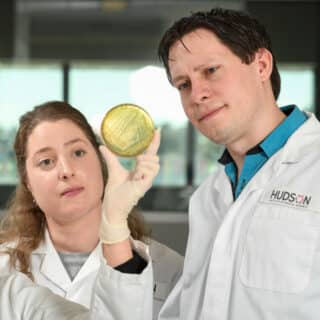 Dr Gemma D'Adamo and A/Prof Sam Forster examine a cell culture as part of their research into the role of the microbiome in inflammatory bowel disease (IBD).